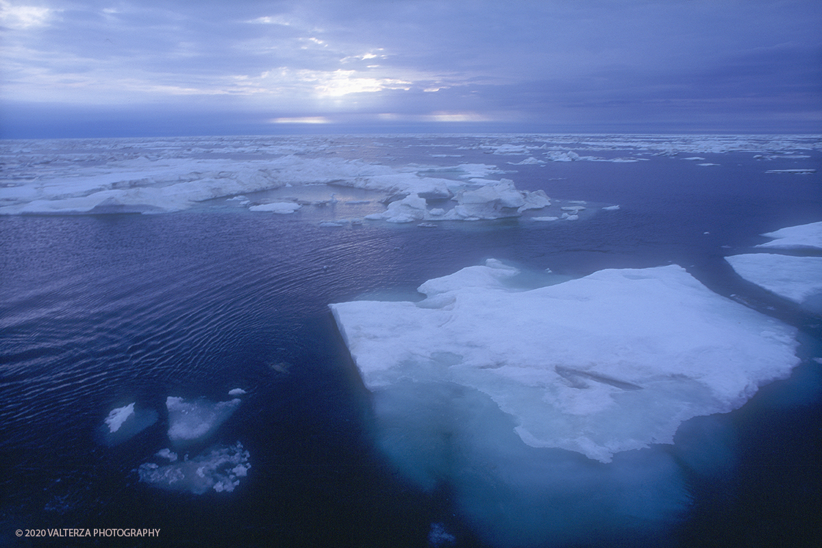 56 SIBERIA.jpg - Luglio/Agosto 1992. Siberia, terra dei Chukchi. Nell'oceano artico  125 Km a nord-est della penisola dei Chukchi (Siberia) c'Ã¨ l'isola di Wrangel, essa ospita piÃ¹ del doppio di specie vegetali (417) di qualsiasi territorio artico a paritÃ  di superficie nonchÃ¨ 30 specie diverse di uccelli oltre ad orsi polari, foche e trichechi ; per questo motivo   Ã¨ stata proclamata patrimonio dell'umanitÃ  dall'UNESCO. Nella foto Le luci dell'alba sul pack nel mare di Bering mentre si naviga verso l'isola di Wrangel